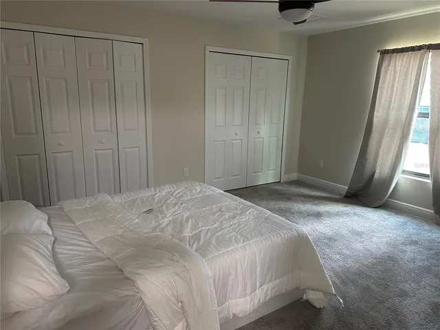 a spacious bedroom with a bed and a window