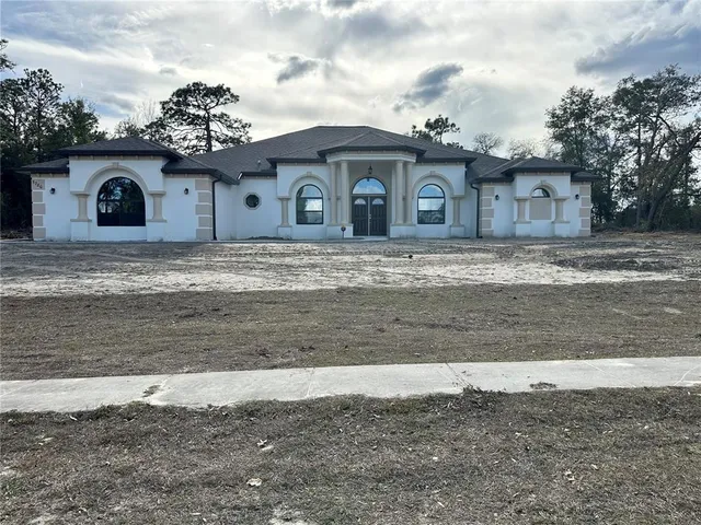 a front view of a house with a garden