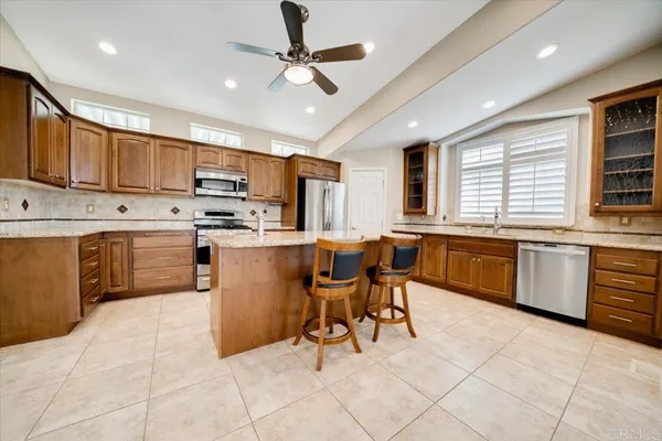 a kitchen with stainless steel appliances kitchen island granite countertop a sink counter space cabinets and a center island