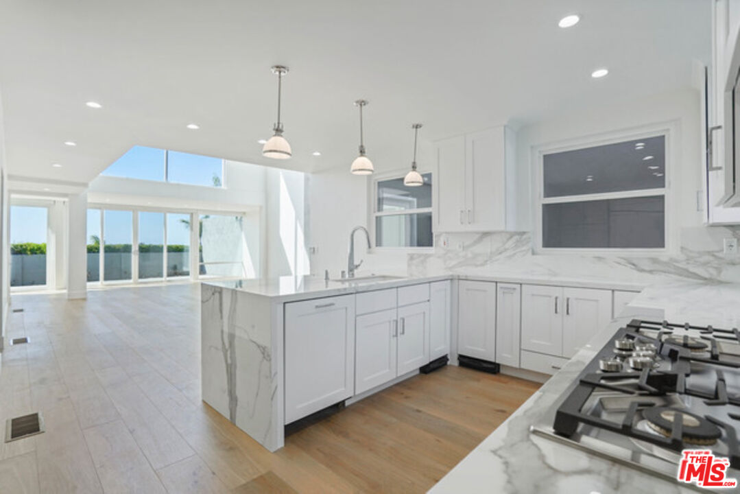 7263 Birdview Avenue Malibu, CA 90265 - Photo 3 of 17 a kitchen with stainless steel appliances granite countertop a stove and a sink