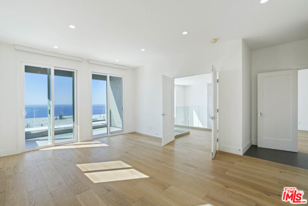 7263 Birdview Avenue Malibu, CA 90265 - Photo 8 of 17 an empty room with wooden floor and windows