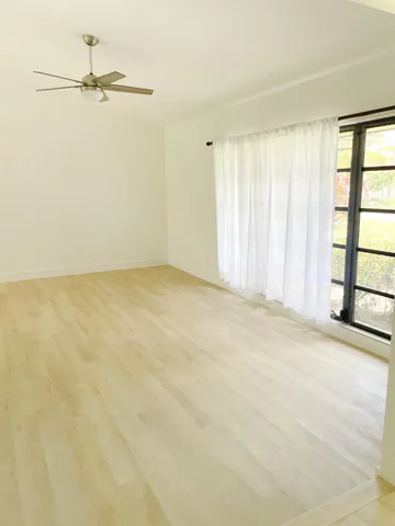 a view of a room with a window and a ceiling fan