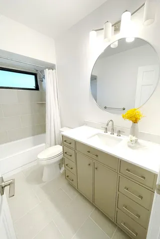 a bathroom with a double vanity sink toilet and shower