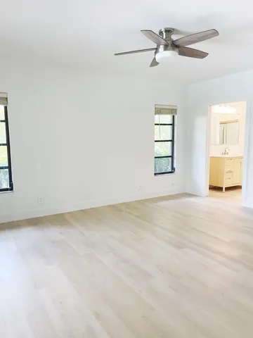 an empty room with a window and a ceiling fan
