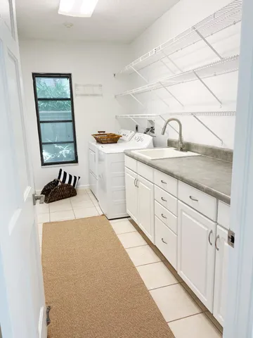 a utility room with sink dryer and washer