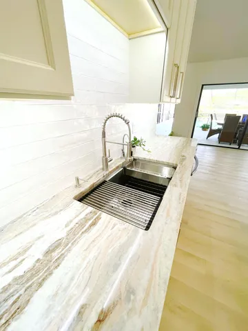 a view of a kitchen with kitchen island and a sink