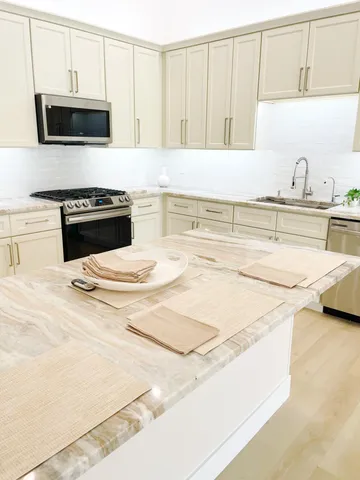 a kitchen with stainless steel appliances a stove a microwave and cabinets