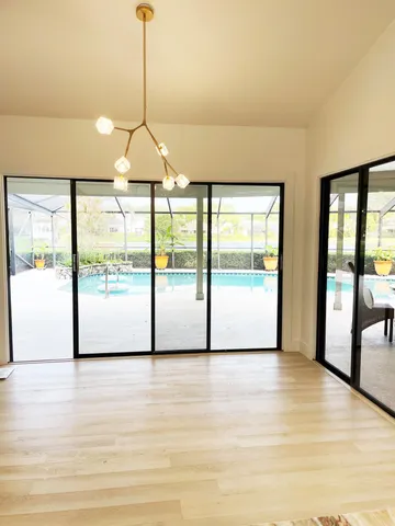 a view of an empty room with glass door and windows