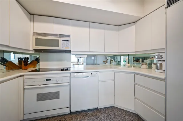 a kitchen with white cabinets and white appliances