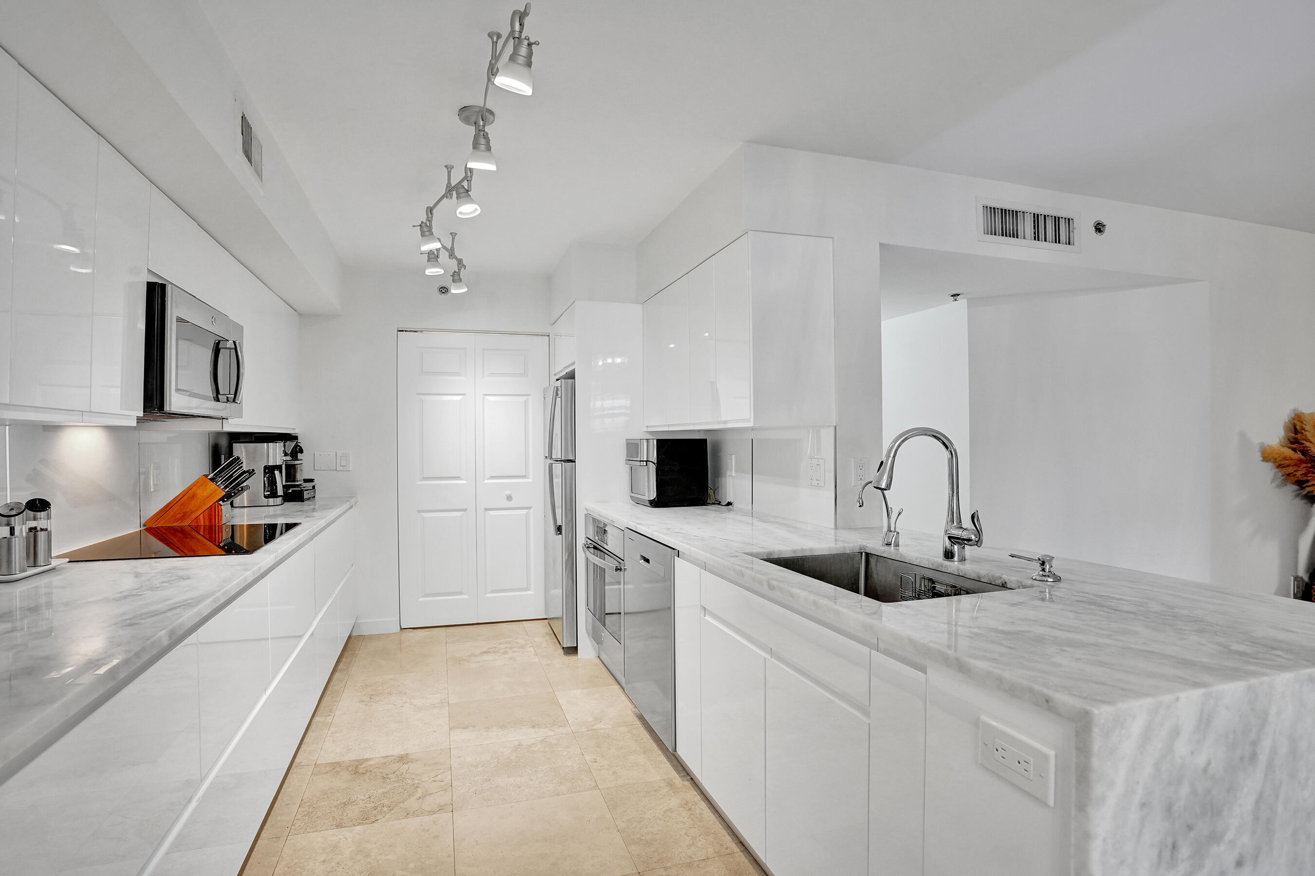 a kitchen with stainless steel appliances a sink a stove top oven a counter space and cabinets