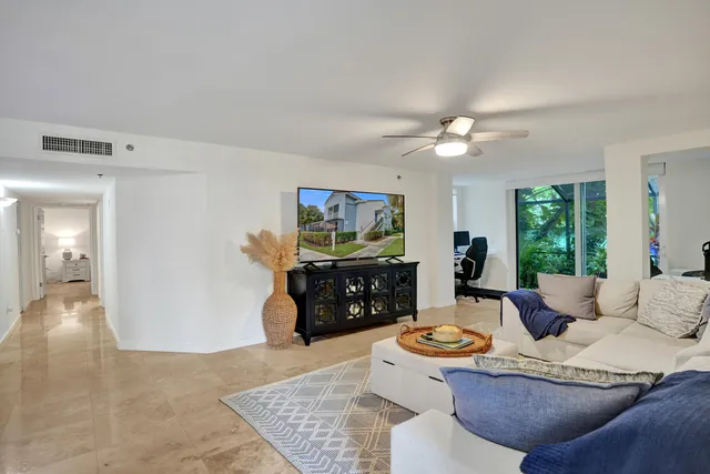 a living room with furniture a flat screen tv and couches
