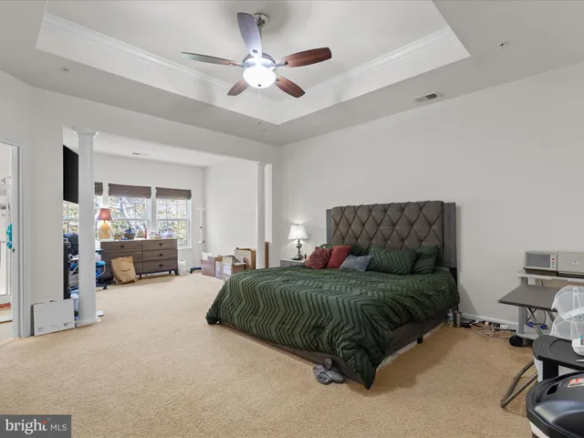 a living room with a bed furniture chandelier and a window