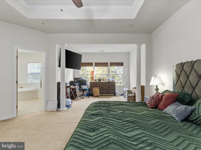 a bedroom with a bed and large windows