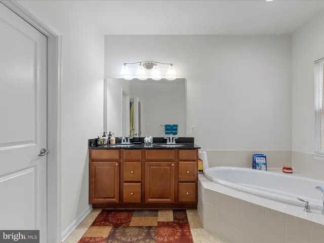 a bathroom with a bathtub a sink and a mirror