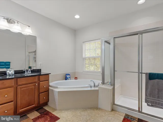 a bathroom with a tub sink and mirror