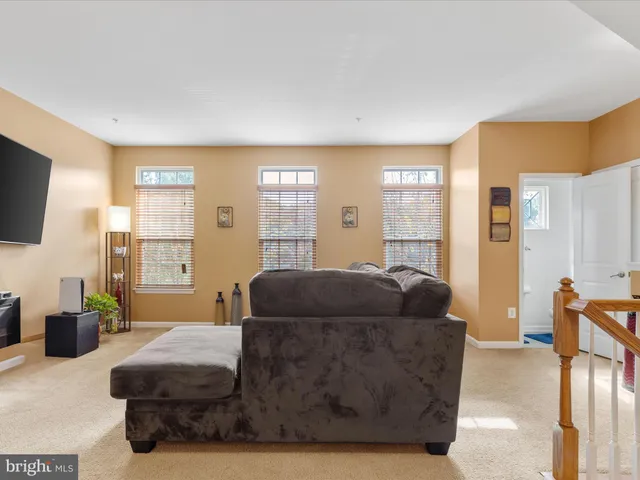 a living room with furniture a flat screen tv and a large window
