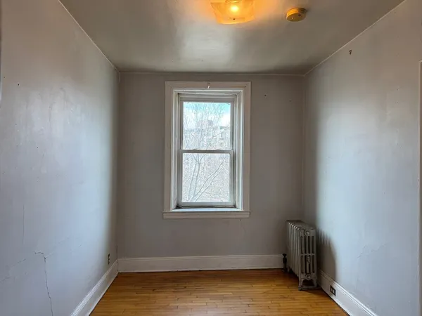a view of a room with wooden floor and a window