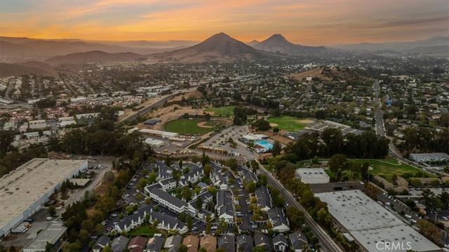 an aerial view of residential house with parking and trees