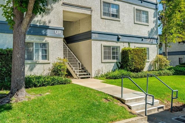 a view of a house with backyard and a tree