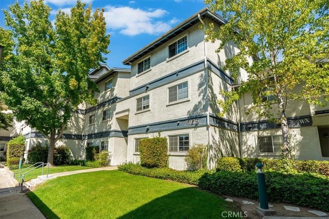 a view of a white house with a big yard and large trees