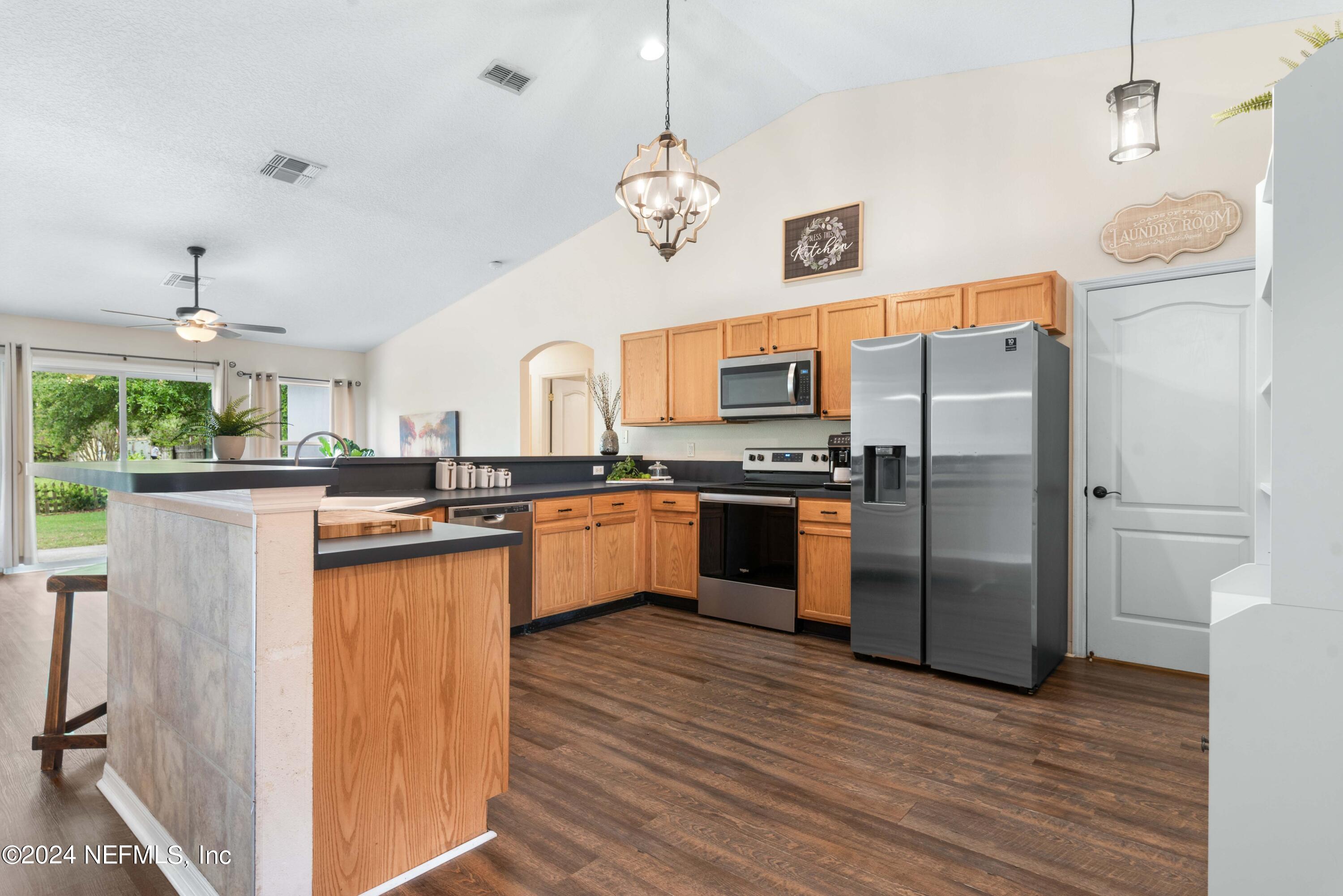 968 Deer Spring Drive Jacksonville, FL 32221 - Photo 8 of 31 a kitchen with stainless steel appliances a refrigerator a sink dishwasher a oven and a dining table with wooden floor