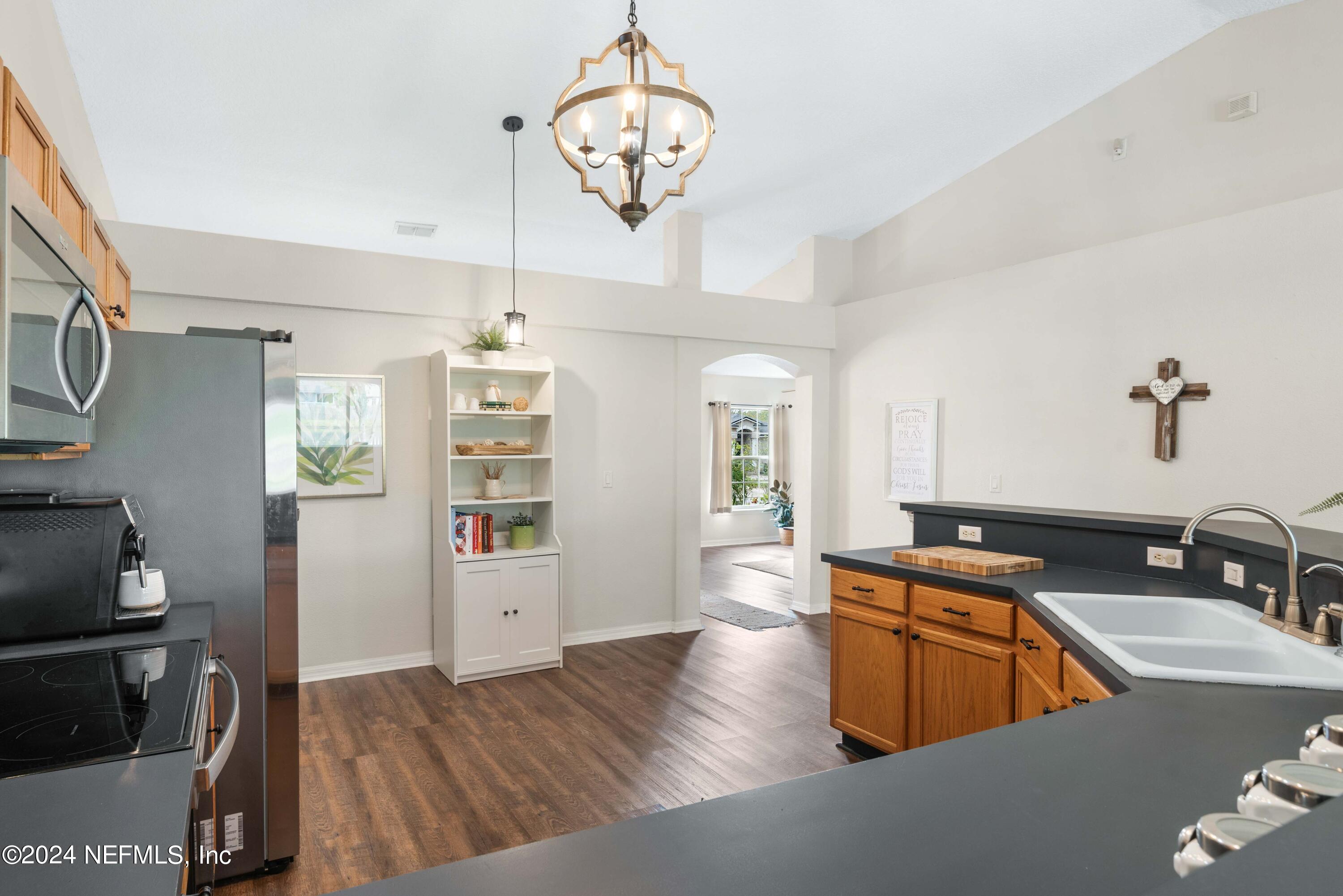 968 Deer Spring Drive Jacksonville, FL 32221 - Photo 10 of 31 a kitchen with stainless steel appliances granite countertop a sink dishwasher stove and refrigerator with wooden floor
