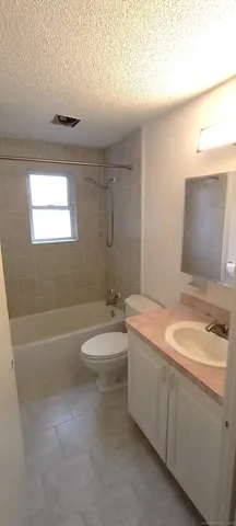 a bathroom with a granite countertop sink a toilet and bathtub