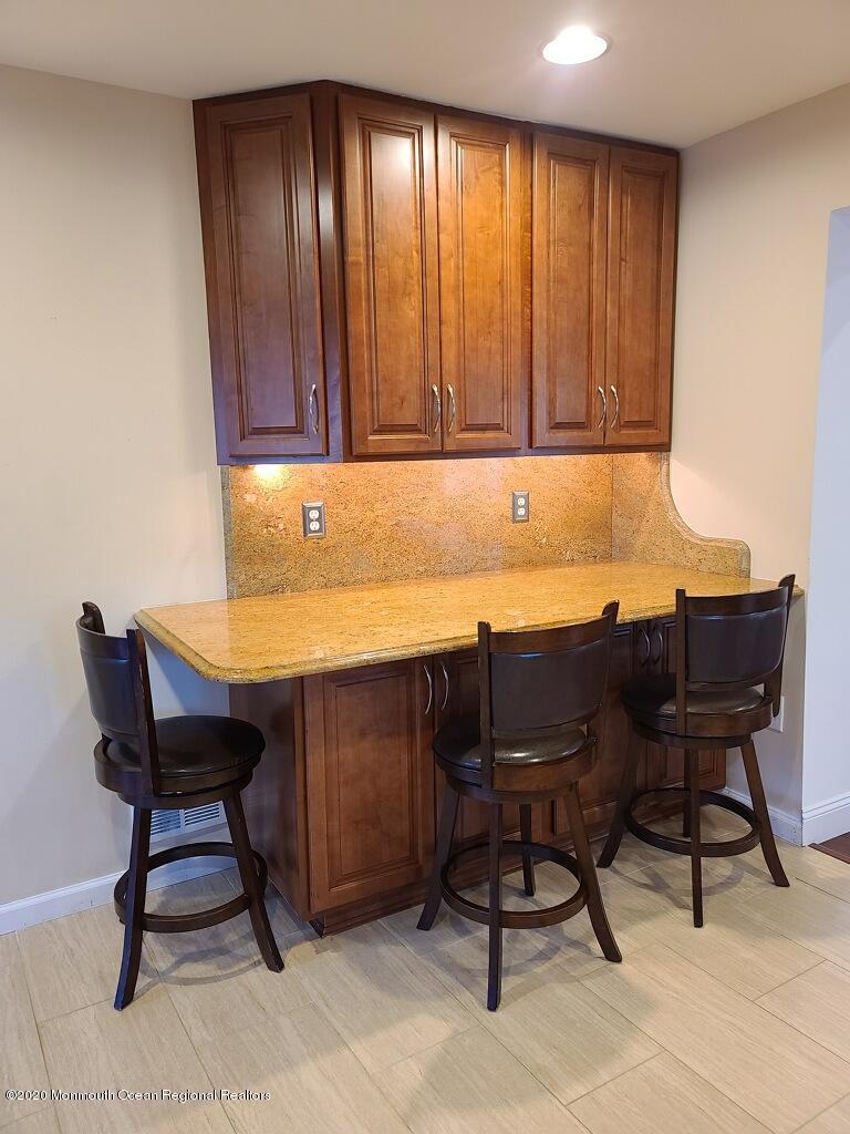 227 Georgia Road Freehold, NJ 07728 - Photo 14 of 79 a room with a desk chairs and a dining table with wooden floor
