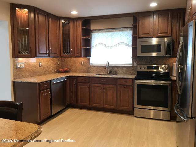 227 Georgia Road Freehold, NJ 07728 - Photo 18 of 79 a kitchen with stainless steel appliances granite countertop a stove a sink and a microwave