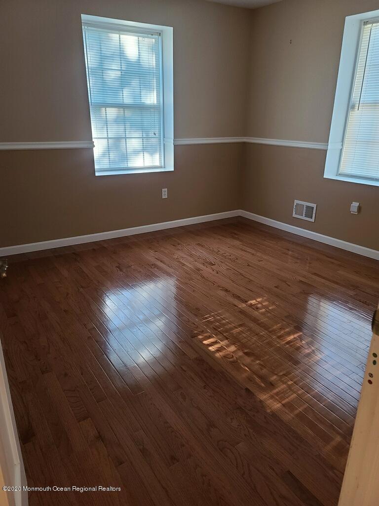227 Georgia Road Freehold, NJ 07728 - Photo 26 of 79 an empty room with wooden floor and windows