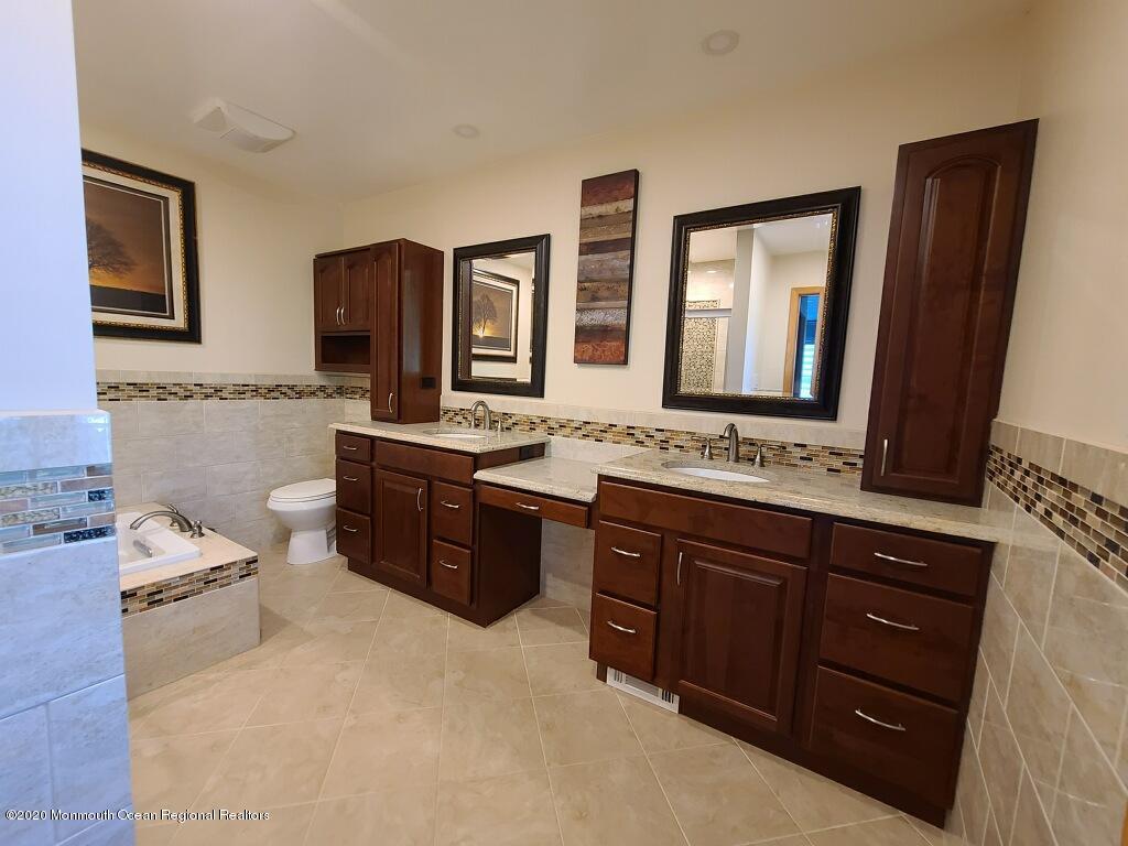 227 Georgia Road Freehold, NJ 07728 - Photo 53 of 79 a spacious bathroom with a granite countertop double vanity sink a mirror and a