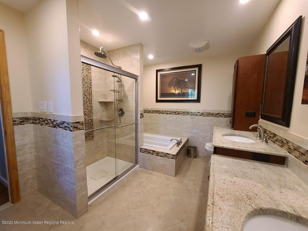 227 Georgia Road Freehold, NJ 07728 - Photo 54 of 79 a bathroom with a tub sink and mirror