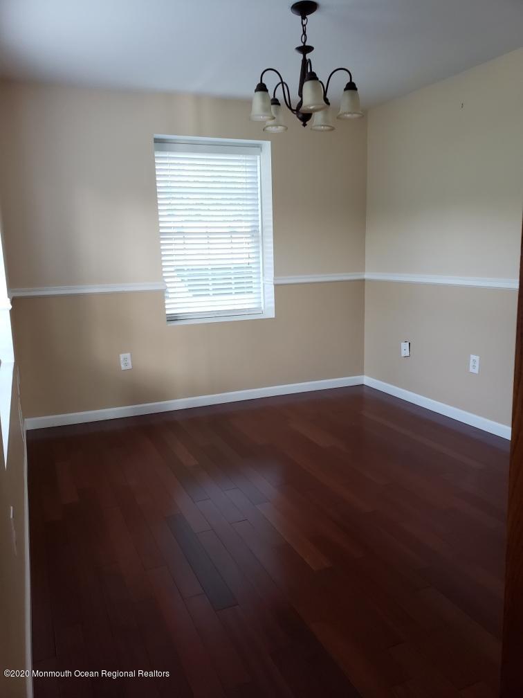 227 Georgia Road Freehold, NJ 07728 - Photo 7 of 79 an empty room with wooden floor cabinet and windows
