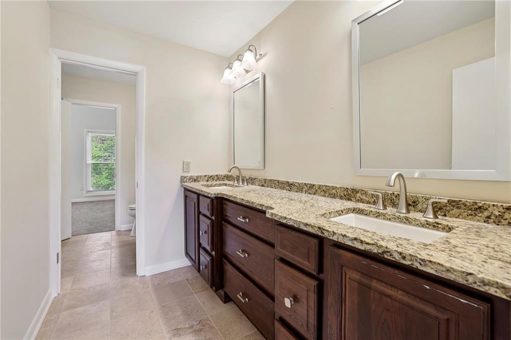 1843 Vancroft Court Atlanta, GA 30338 - Photo 22 of 46 a bathroom with a granite countertop sink and a mirror
