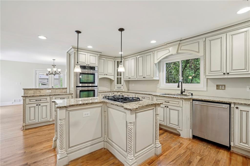 1843 Vancroft Court Atlanta, GA 30338 - Photo 10 of 46 a kitchen with stainless steel appliances granite countertop a stove a sink dishwasher a refrigerator white cabinets and wooden floor next to a window