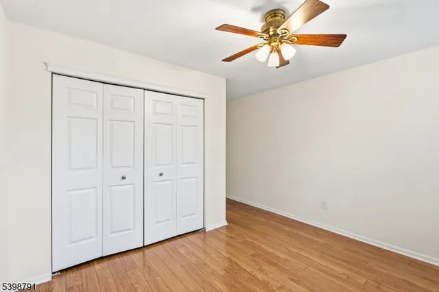 an empty room with a window and a ceiling fan