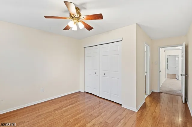 a view of a room with wooden floor a ceiling fan