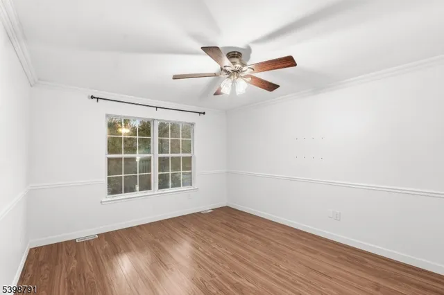 an empty room with a window and a ceiling fan