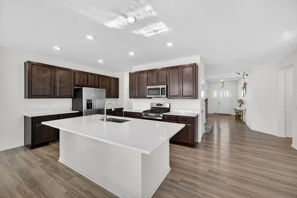 a kitchen with refrigerator cabinets and wooden floor