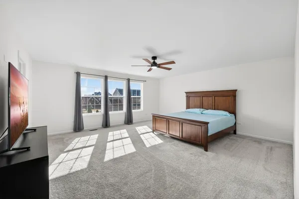 a bedroom with a large bed and a flat tv screen on a dresser
