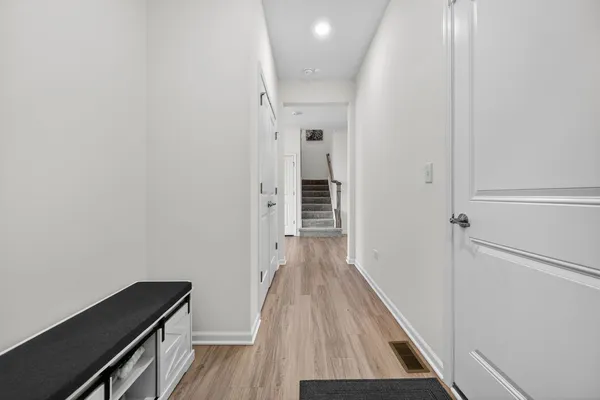 a view of a hallway with wooden floor and staircase