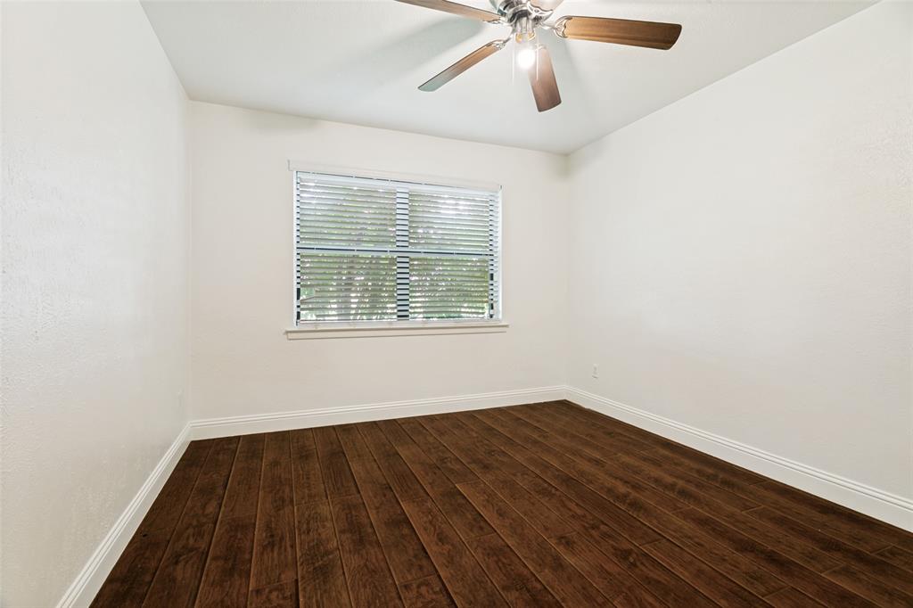 1904 Old Kirk Road Bedford, TX 76022 - Photo 19 of 25 an empty room with wooden floor ceiling fan and windows