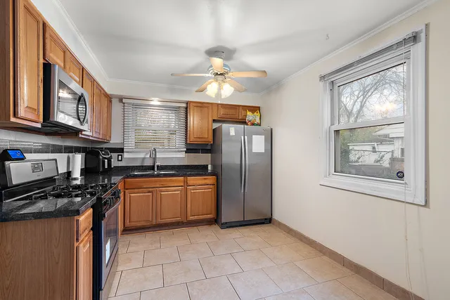 a kitchen with stainless steel appliances granite countertop a refrigerator a stove top oven a sink and dishwasher