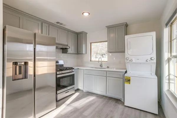 a kitchen with a refrigerator sink and cabinets
