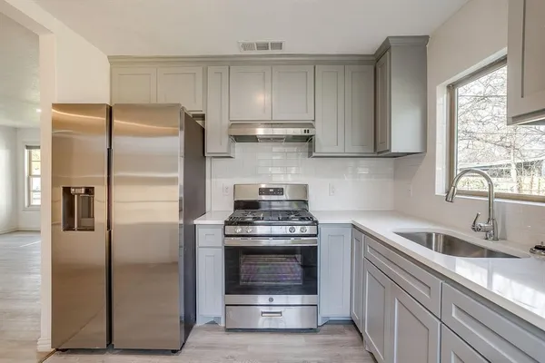 a kitchen with a stove sink and refrigerator
