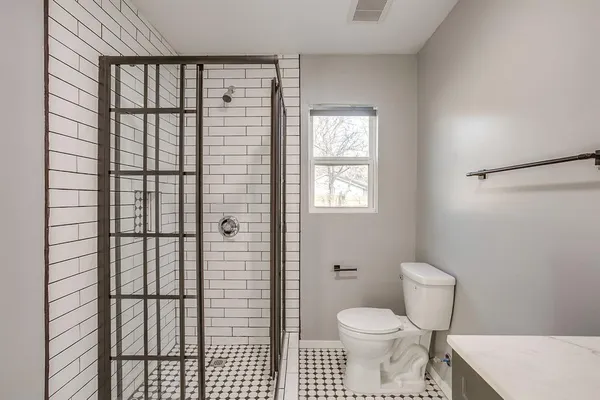 a bathroom with a toilet and a shower