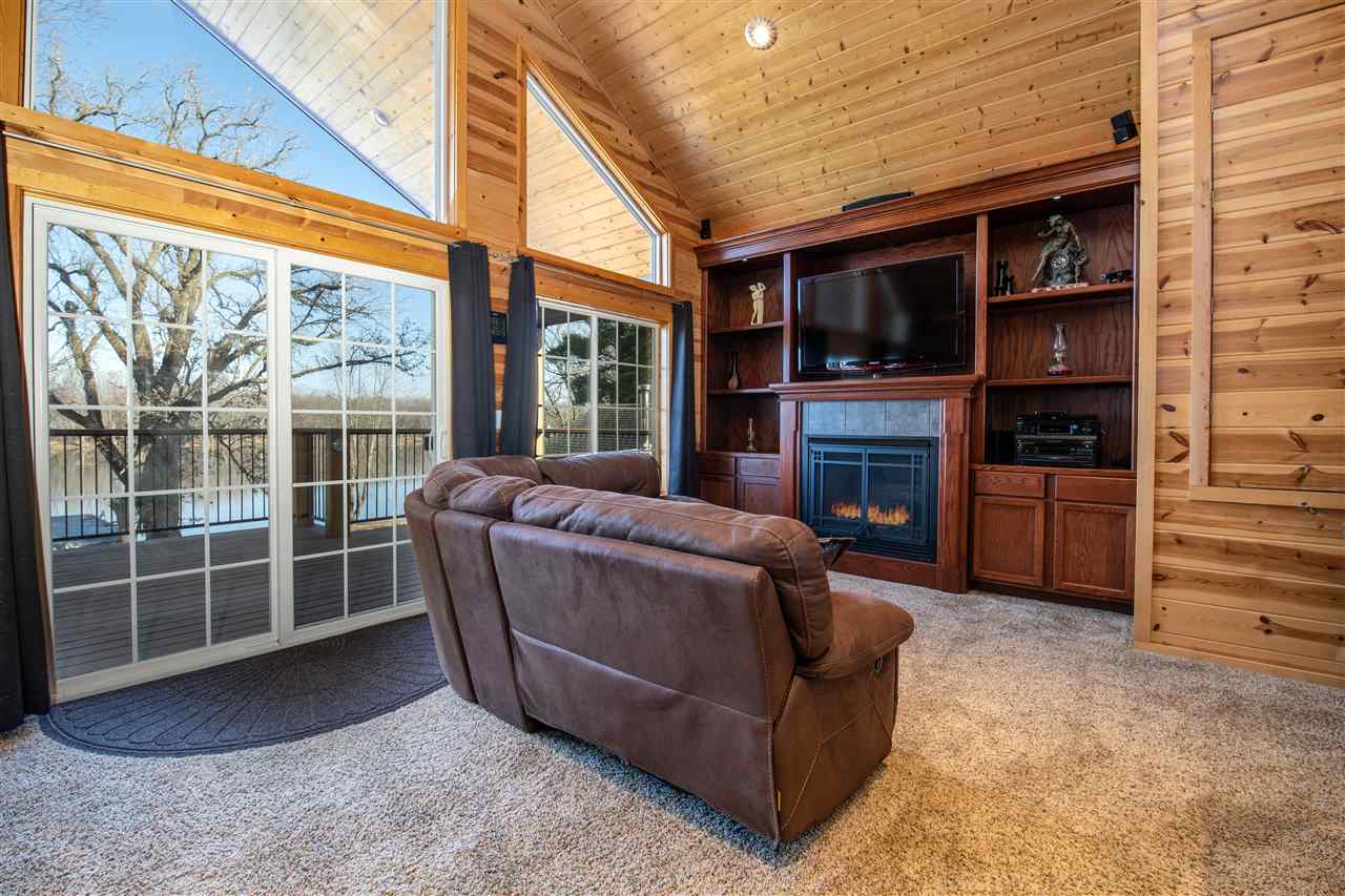 7372 North River Road Byron, IL 61010 - Photo 21 of 40 a living room with furniture a flat screen tv and a fireplace