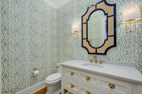 a bathroom with a toilet a sink a mirror and a window