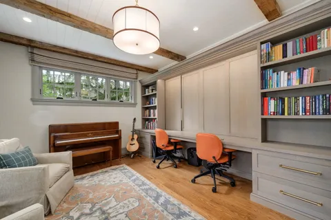 a kitchen with a stove a sink a dining table and chairs with wooden floor
