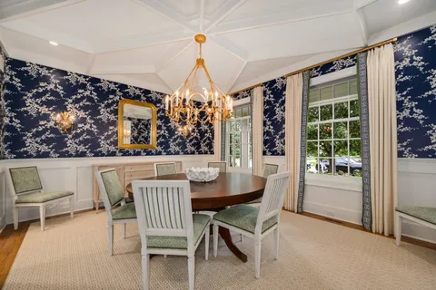 a dining room with furniture a chandelier and wooden floor